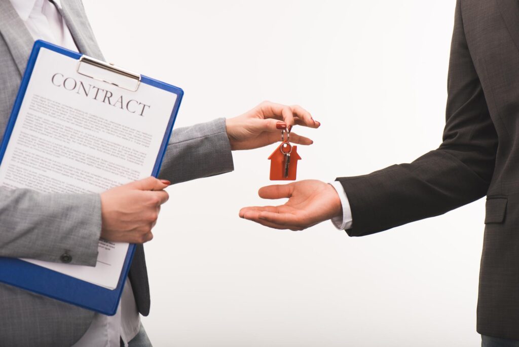 A real estate agent handing keys to a new home owner