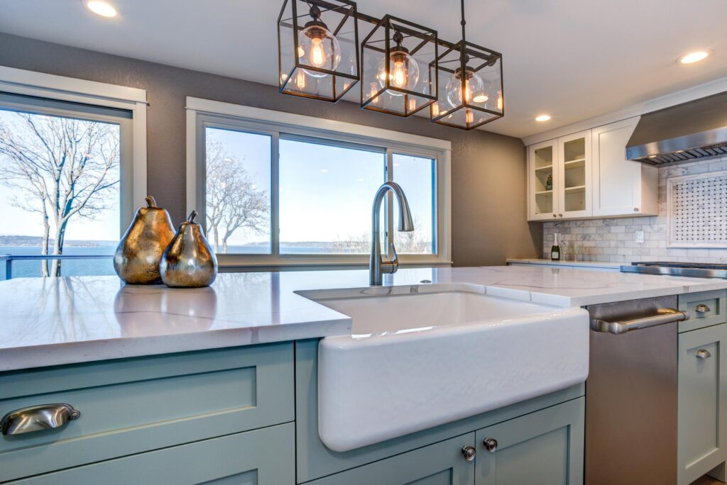 Farmhouse kitchen with green island and farmhouse sink.