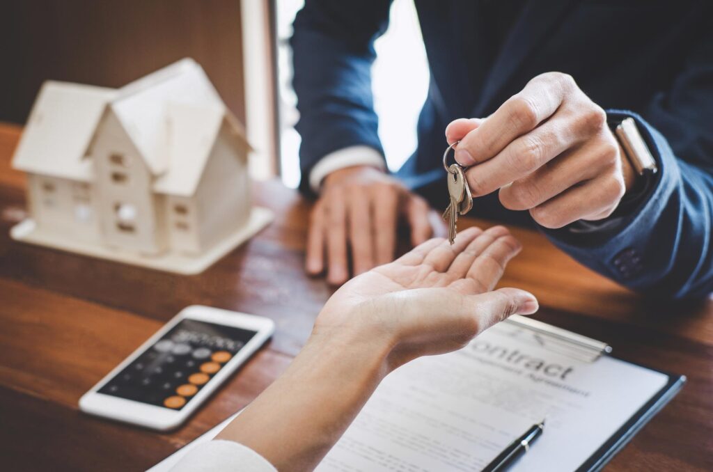 Getting approved for a mortgage. Real estate agent Sales manager holding filing keys to customer after signing rental lease contract of sale purchase agreement, concerning mortgage loan offer for and house insurance.