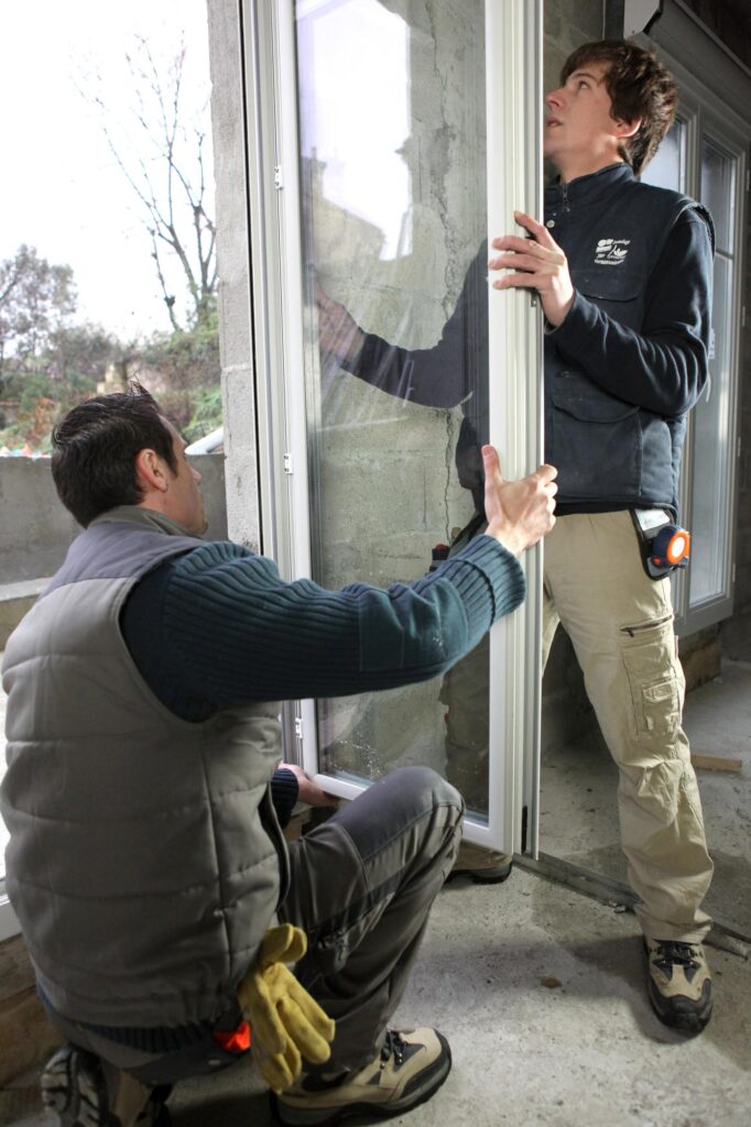 Increase value of your home before selling with two workers fitting in new windows.