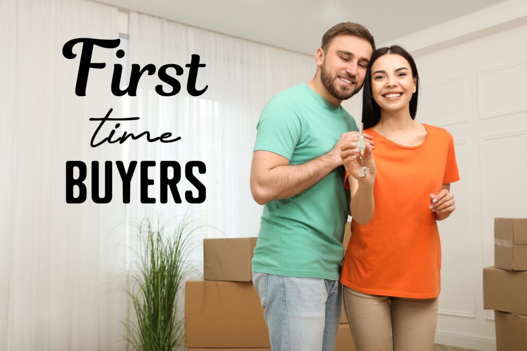 Man and woman holding keys to their new home with boxes all around